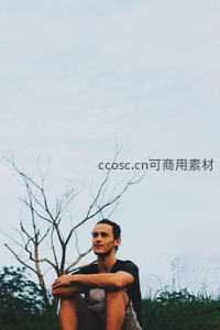 青年男子户外草地微笑凝望远方