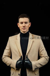 米色西装搭配黑色高领毛衣的时尚男士