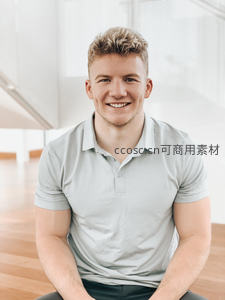 微笑青年身穿浅灰Polo衫坐于明亮室内