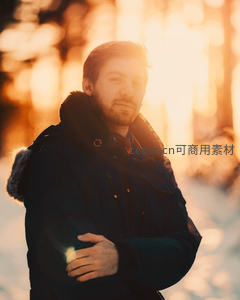 冬日暖阳下穿羽绒服的沉思男子