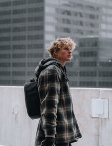雪中少年格子衫背包城市侧影