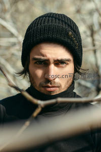 林中戴帽男子眼神锐利特写