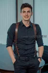 穿背带衬衫的男士微笑站立，商务休闲风