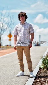 阳光下微笑青年，休闲穿搭显活力