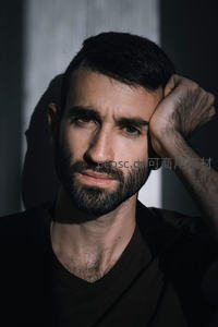 深色光影中的沉思男性特写