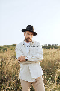 戴帽男子田野中沉思凝望