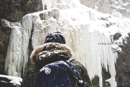 雪中旅人仰望冰瀑奇观震撼自然
