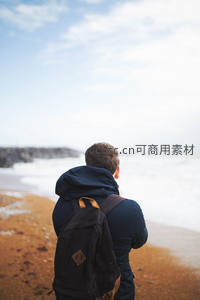 男子海边远眺浪花拍岸心旷神怡