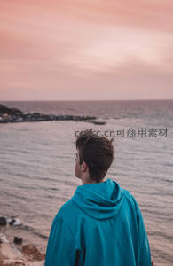 少年面朝大海，粉霞染红天际