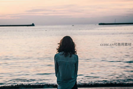 夕阳下女子伫立海岸远眺