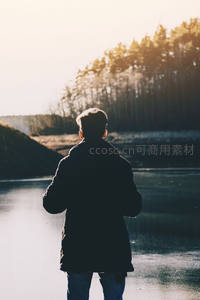 湖畔少年迎光而立背影如画