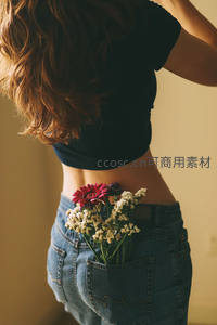 花束点缀牛仔裤后袋的时尚背影