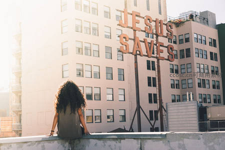 城市屋顶沉思，耶稣拯救标语引人深思
