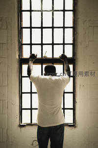 男子背影推窗凝望，光影交错间思绪万千