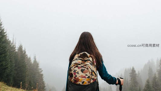 雾中徒步者背影，远眺苍翠山林