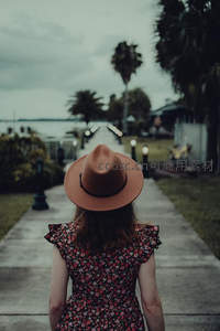 棕帽少女漫步棕榈树小径