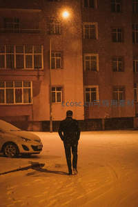 雪夜街灯下，孤影踏雪归家路