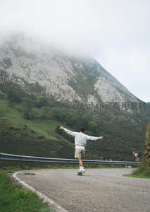 少年滑板驰骋山间公路，云雾缭绕