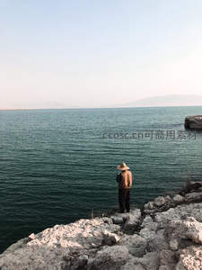 渔夫立崖眺望碧水，远山如黛