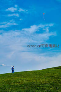 绿野之上蓝衣人放飞红风筝，晴空万里云卷云舒