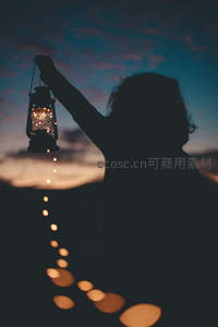 剪影举灯映霞光，点点暖光引路归