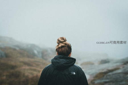 雾中远眺山峦的孤独旅人背影