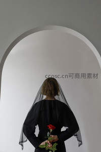 黑纱新娘手捧红玫瑰伫立拱门