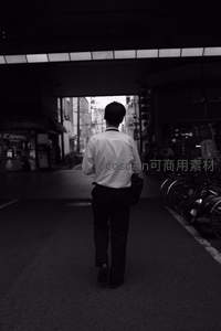 黑白街巷中独行的上班族背影