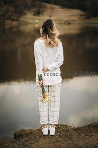 湖畔持花沉思的女子