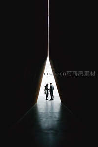 光影缝隙中情侣相依而立