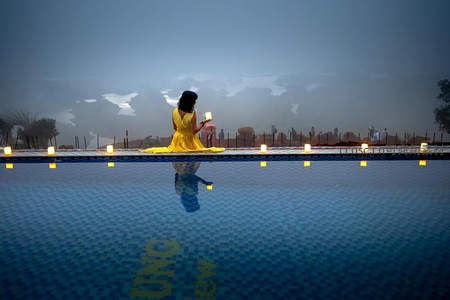 泳池边黄裙女子手持灯盏倒影如画