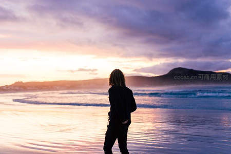 夕阳沙滩剪影，一人静赏海浪与晚霞