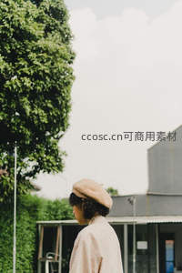 街角少女侧影，绿树灰墙间的日常诗意