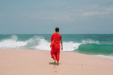 红袍僧人赤足漫步碧海沙滩