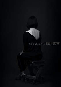 黑衣女子背坐木凳黑白照