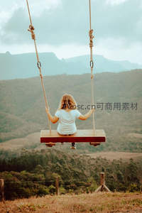 女孩荡秋千俯瞰山野风光