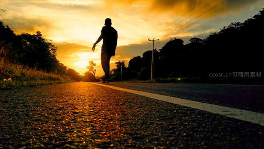 夕阳剪影滑板少年在路上