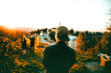 夕阳下男子驻足俯瞰小镇风光