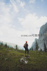 登山者立于高山草甸远眺峡谷