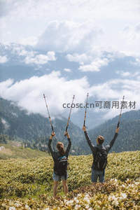 山巅徒步者举杖庆祝壮丽云海