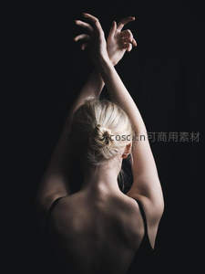 芭蕾舞者暗影中舒展双臂