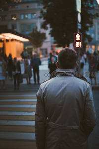 黄昏街角，男子伫立斑马线前等待过街