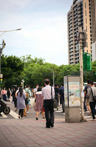 都市人潮中，上班族缓步走过街角路口