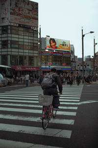 骑行者穿行于繁华都市十字路口
