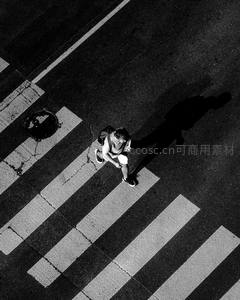 黑白俯拍行人过街，长影拉伸显孤独