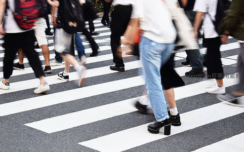 人群匆忙穿行于斑马线上的动态瞬间