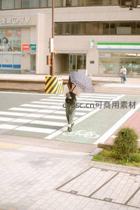 雨后街角，行人撑伞过斑马线