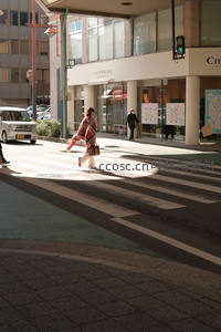 阳光斑驳的街角，行人匆匆走过人行道