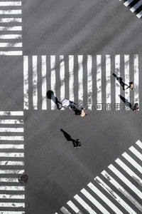 高空俯瞰十字路口，行人如棋子般穿梭其间