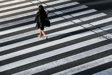 俯瞰单人穿越斑马线，黑白光影勾勒都市孤独行者
